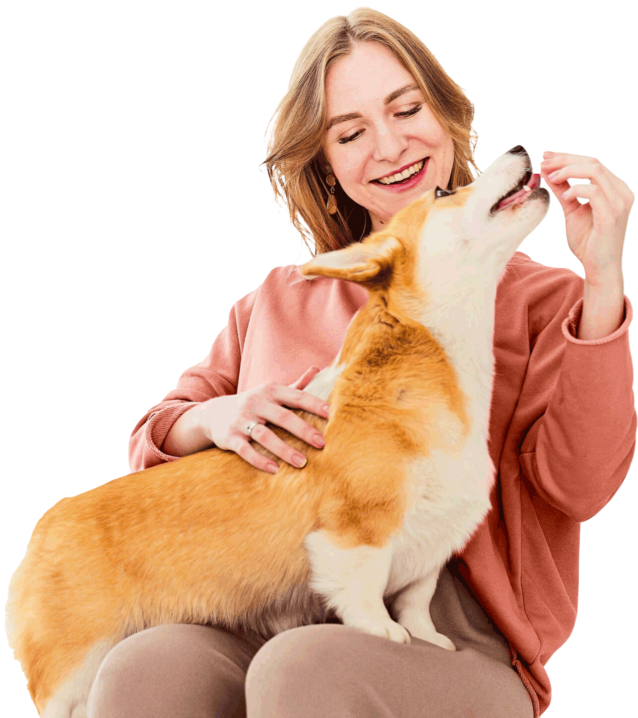 A happy woman feeding her dog